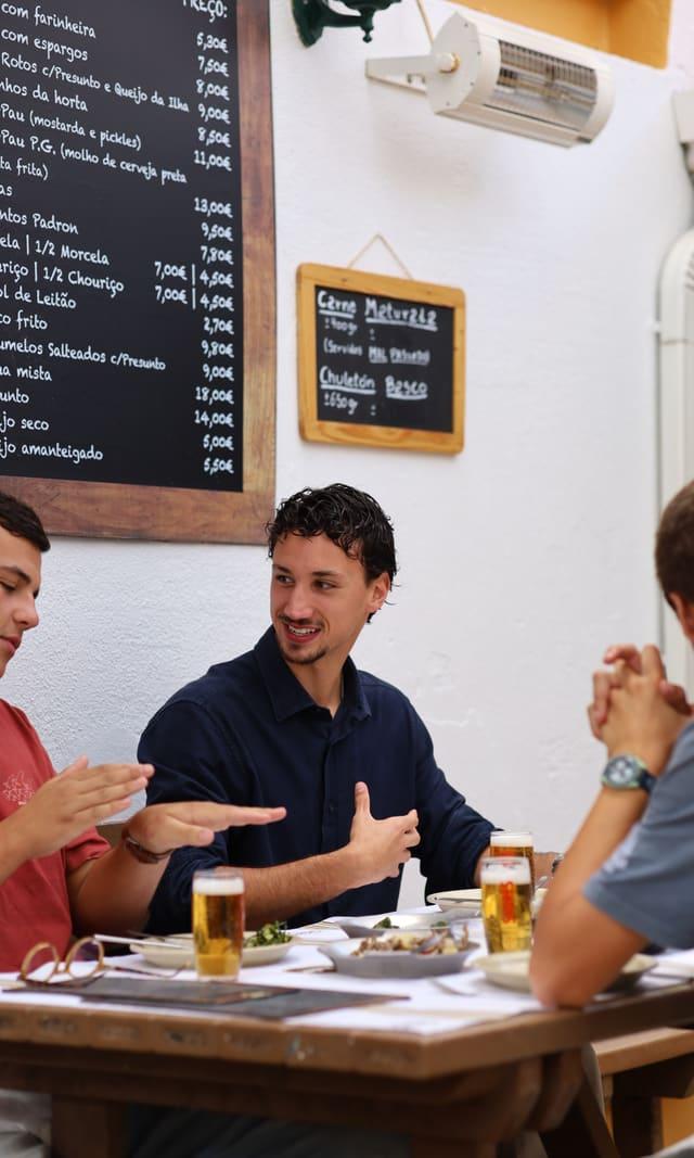 Diners talking at the table with the day's menu behind