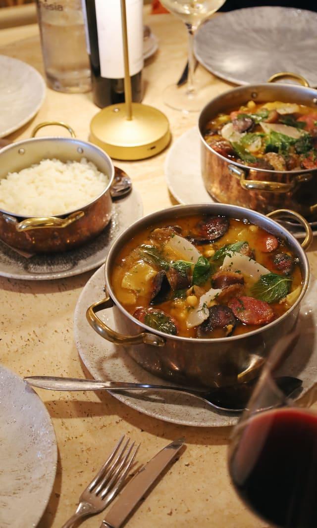 Table set with a stew and a glass of wine