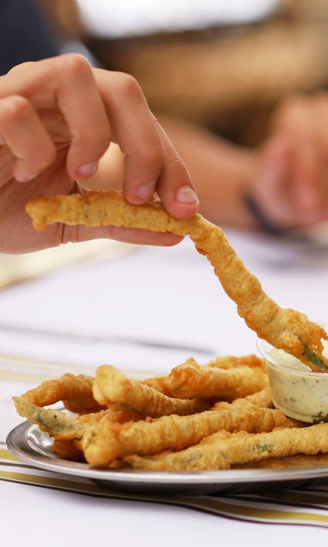 Crispy fried strips being dipped in sauce