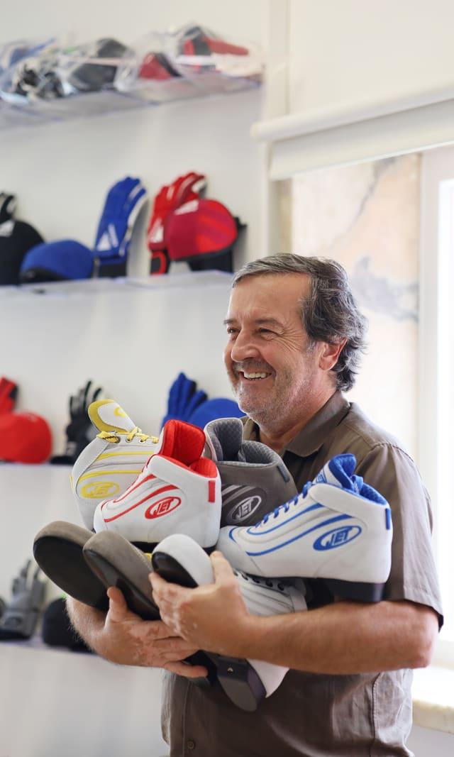 Shopkeeper smiling with an armful of JET trainers